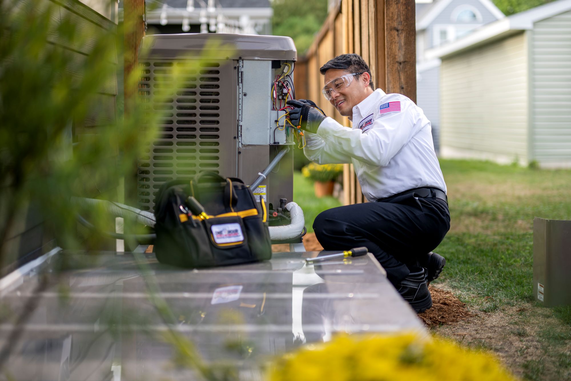 HVAC business owner in One Hour uniform working on an AC unit.
